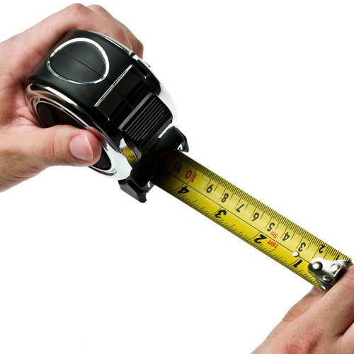 Hands holding measuring tape - Keystone Carpets Inc in WA